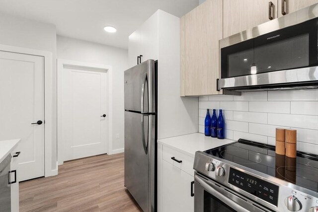 10 Somerset Unit 403, Winthrop, MA 02152 - kitchen with stainless steel appliances, light countertops, tasteful backsplash, light wood-style flooring, and recessed lighting