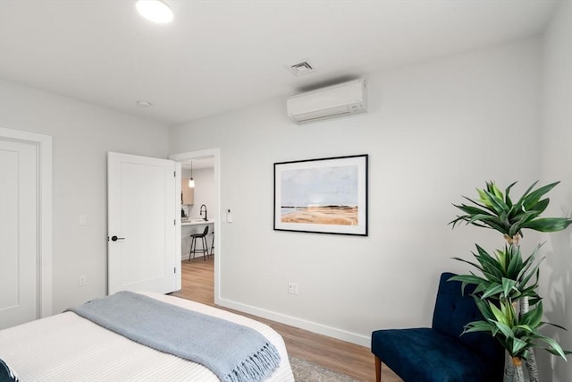 10 Somerset Unit 403, Winthrop, MA 02152 - bedroom featuring an AC wall unit, light wood-style floors, and baseboards