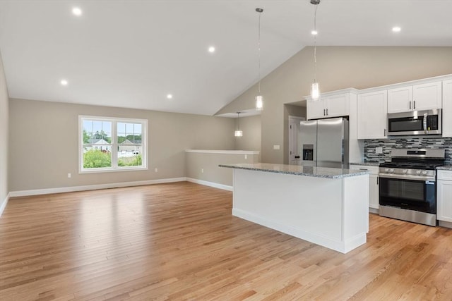 4 Bronson St, Fall River, MA 02721 - kitchen featuring appliances with stainless steel finishes, a center island, white cabinetry, decorative backsplash, and hanging light fixtures