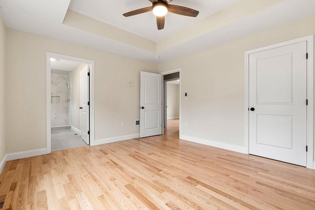 4 Bronson St, Fall River, MA 02721 - unfurnished bedroom featuring light wood-style flooring, a tray ceiling, and ensuite bathroom