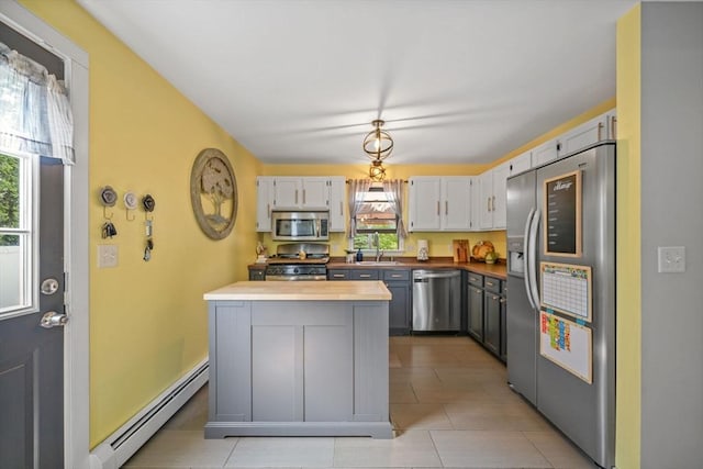 217 Hathaway Commons Rd, Fall River, MA 02720 - kitchen with appliances with stainless steel finishes, a baseboard heating unit, white cabinetry, butcher block countertops, and a center island