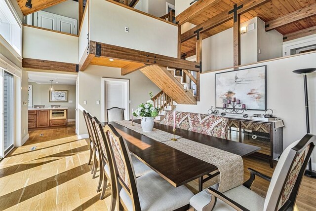 17 Wagon Wheel Rd, Winchester, MA 01890 - dining area with light wood-type flooring, stairway, wood ceiling with exposed beams, a high ceiling, and baseboards