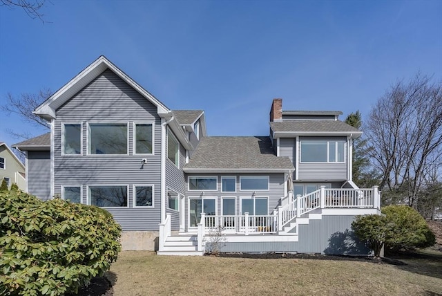 17 Wagon Wheel Rd, Winchester, MA 01890 - back of house featuring a chimney, a yard, a shingled roof, and a wooden deck