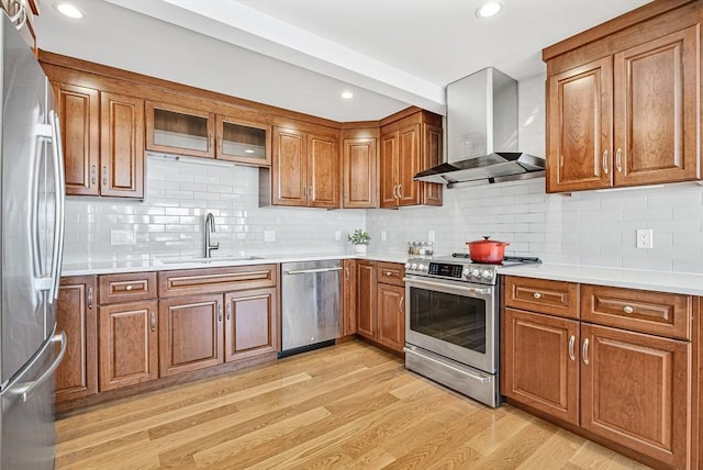 17 Wagon Wheel Rd, Winchester, MA 01890 - kitchen with appliances with stainless steel finishes, a sink, wall chimney exhaust hood, brown cabinetry, and recessed lighting