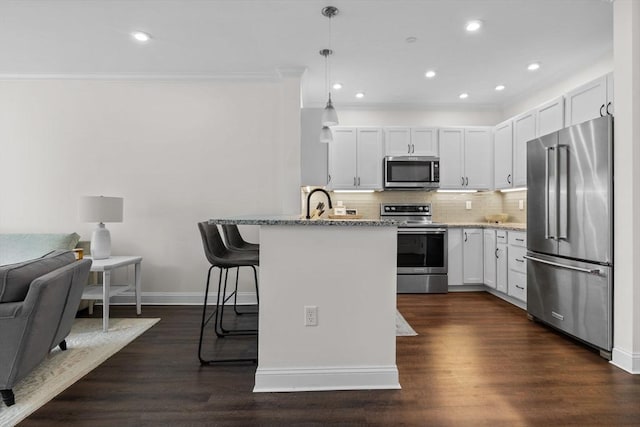69 Foundry St Unit 305, Wakefield, MA 01880 - kitchen with appliances with stainless steel finishes, crown molding, a breakfast bar area, light stone counters, and open floor plan