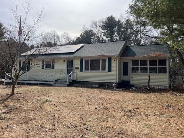 single story home featuring entry steps and roof mounted solar panels