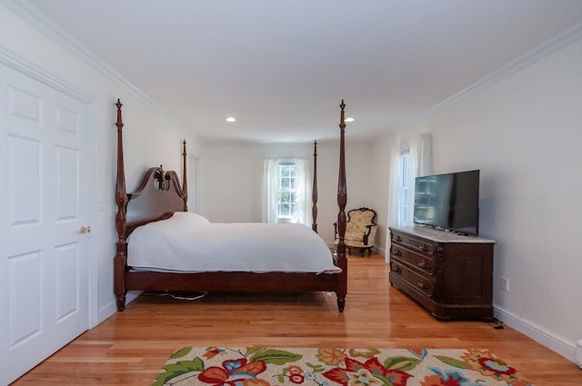 bedroom with ornamental molding and light hardwood / wood-style flooring