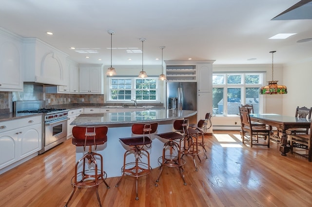 kitchen featuring a kitchen island, light wood-type flooring, appliances with stainless steel finishes, and white cabinets