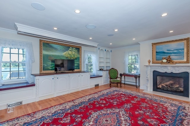 living room with hardwood / wood-style floors, ornamental molding, and a premium fireplace