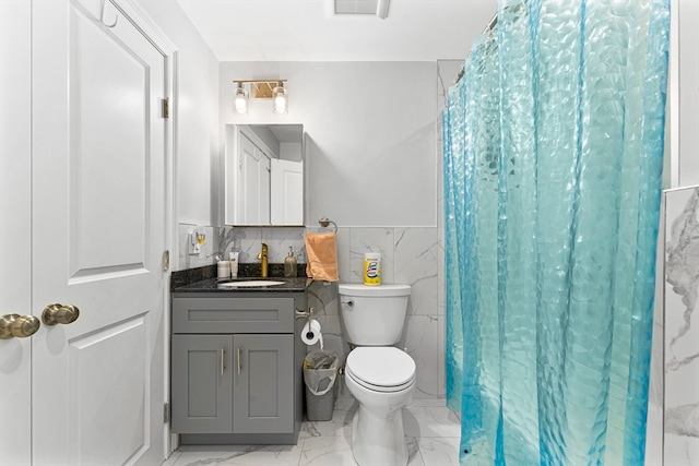 bathroom with a shower with curtain, vanity, toilet, and tile walls