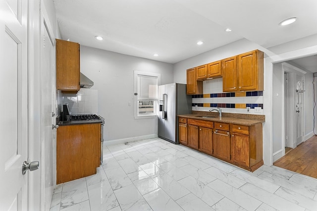 kitchen with appliances with stainless steel finishes, sink, tasteful backsplash, and exhaust hood