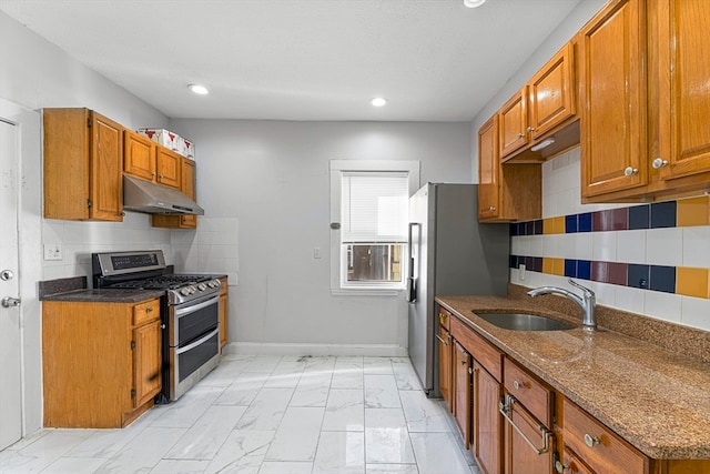 kitchen with backsplash, double oven range, dark stone countertops, and sink