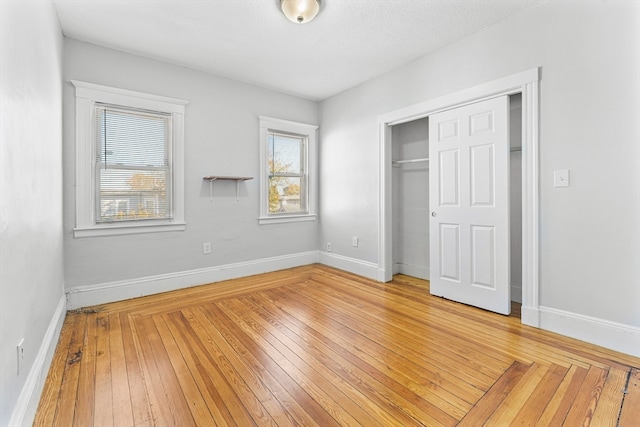 unfurnished bedroom with a closet and hardwood / wood-style flooring