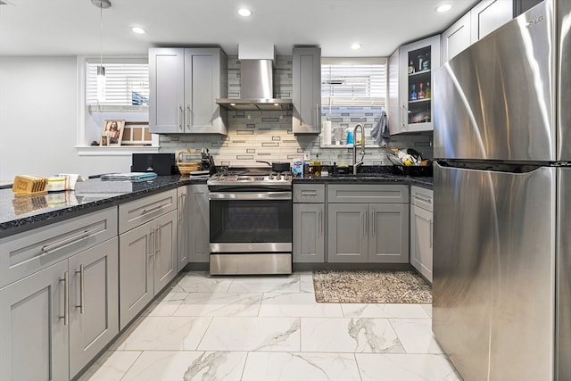 kitchen with pendant lighting, gray cabinetry, dark stone counters, sink, and appliances with stainless steel finishes