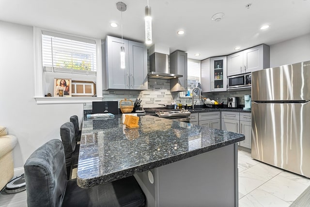 kitchen featuring gray cabinetry, backsplash, dark stone countertops, decorative light fixtures, and appliances with stainless steel finishes