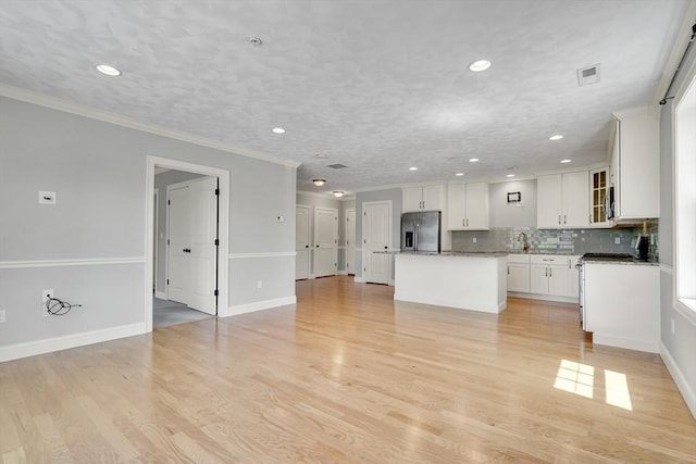 15 Church St Unit 201, Wilmington, MA 01887 - kitchen with stainless steel fridge with ice dispenser, a center island, decorative backsplash, white cabinets, and glass insert cabinets