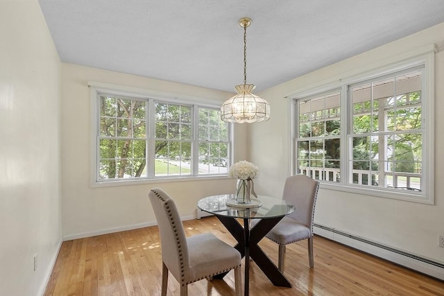 4 Quail Run Dr, Methuen, MA 01844 - dining area with a baseboard heating unit, a chandelier, light wood-style flooring, and baseboards