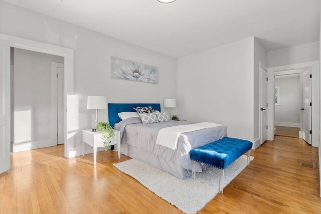 bedroom with baseboards and light wood finished floors