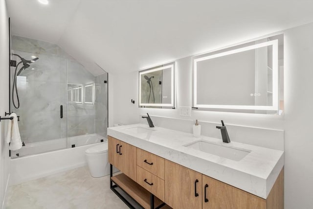 bathroom with lofted ceiling, toilet, double vanity, and a sink