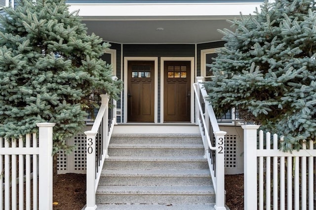 property entrance with a porch and fence