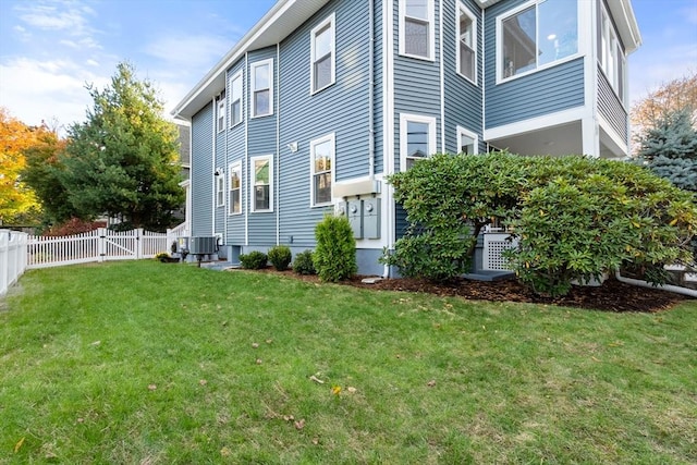 view of property exterior with a gate, a yard, and fence