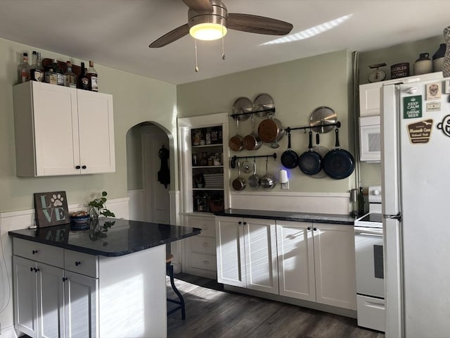 kitchen featuring white appliances, ceiling fan, white cabinetry, dark hardwood / wood-style floors, and kitchen peninsula