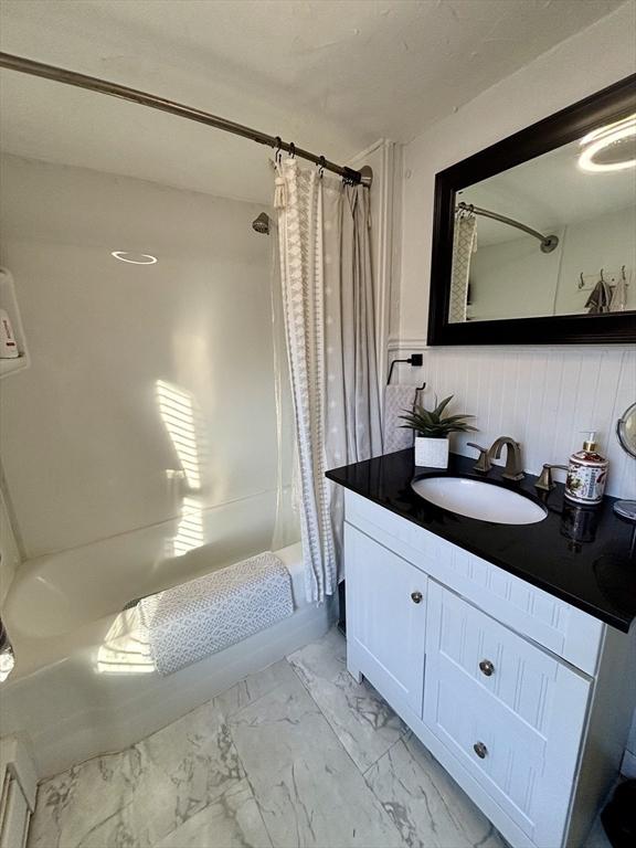 bathroom with shower / tub combo and vanity