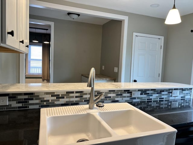 kitchen featuring decorative light fixtures, sink, and decorative backsplash