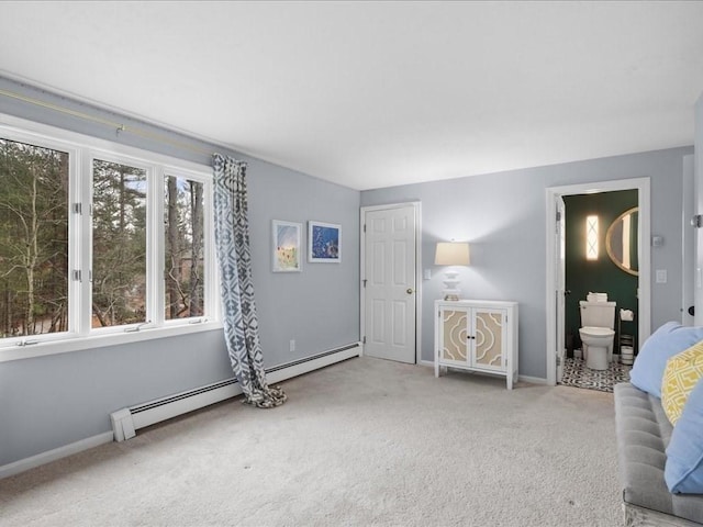 bedroom featuring carpet, ensuite bathroom, and a baseboard heating unit