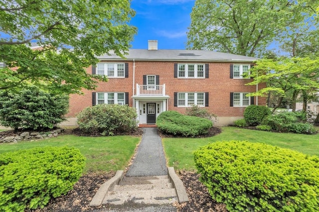 7 Hammond Pond Pkwy Unit 1, Newton, MA 02467 - view of front facade featuring a balcony, brick siding, a chimney, and a front yard