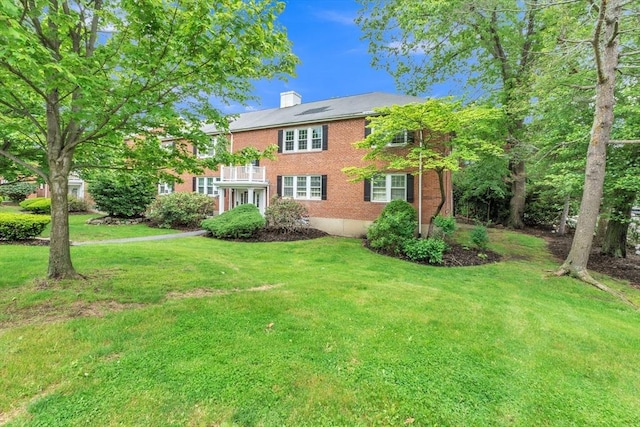 7 Hammond Pond Pkwy Unit 1, Newton, MA 02467 - view of front of home with a chimney, a front lawn, a balcony, and brick siding