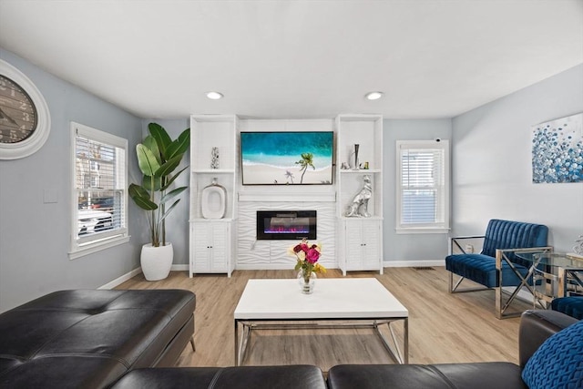 227 Myrtle St, Rockland, MA 02370 - living area featuring a wealth of natural light, a glass covered fireplace, baseboards, and wood finished floors