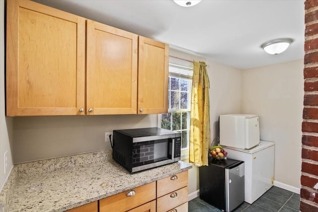 859 Pleasant St, Canton, MA 02021 - kitchen featuring stainless steel microwave, refrigerator, baseboards, light stone countertops, and light brown cabinetry