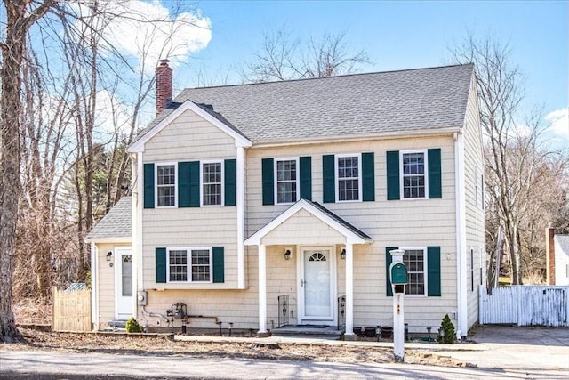859 Pleasant St, Canton, MA 02021 - view of front of house featuring fence, a shingled roof, and a chimney