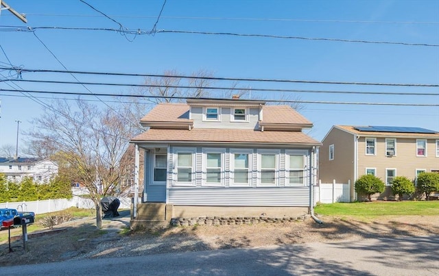 bungalow with roof with shingles, a chimney, and fence