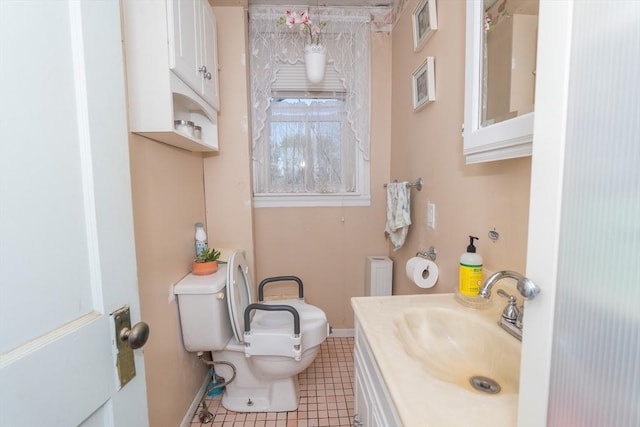 half bathroom featuring toilet, tile patterned floors, vanity, and baseboards