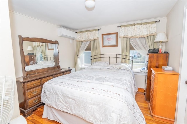 bedroom featuring ornamental molding, a wall unit AC, and wood finished floors