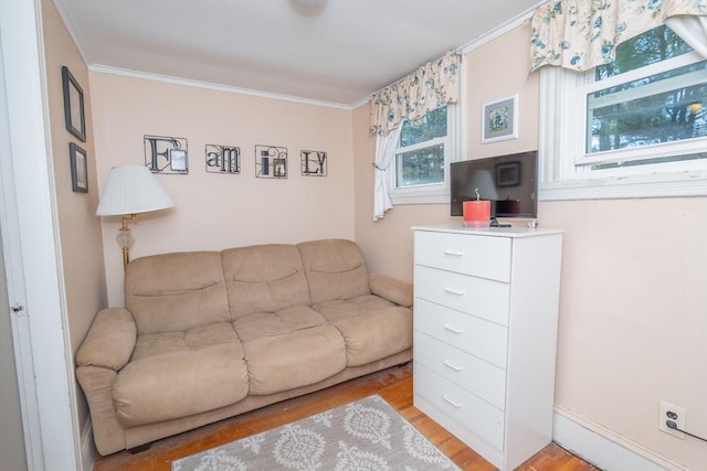 living area with crown molding and light wood finished floors