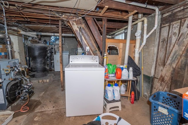 unfinished below grade area featuring independent washer and dryer and a heating unit