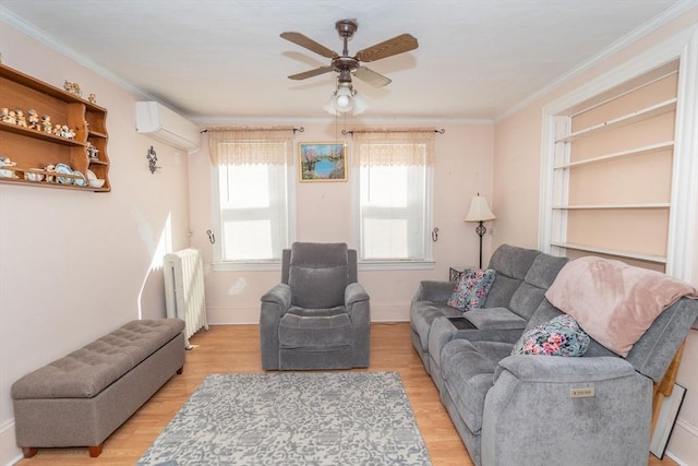 living area with a wall unit AC, crown molding, ceiling fan, light wood finished floors, and radiator heating unit