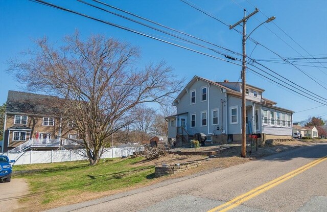 view of front of home featuring fence and a front lawn