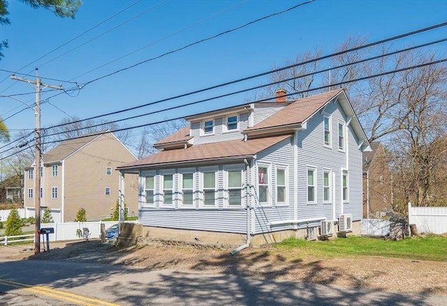bungalow-style house featuring central AC unit, a chimney, a shingled roof, and fence