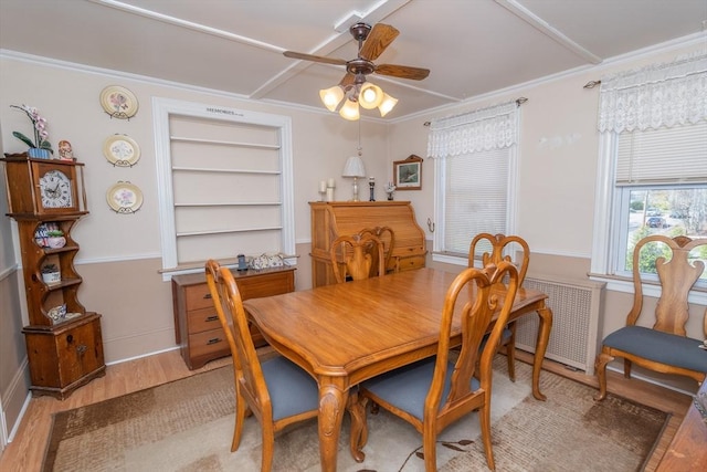 dining room featuring built in features, light wood-type flooring, a ceiling fan, baseboards, and ornamental molding