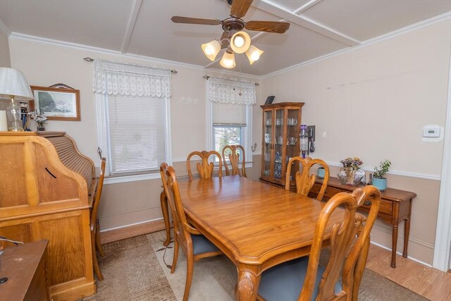 dining space with crown molding, light wood finished floors, a ceiling fan, and baseboards