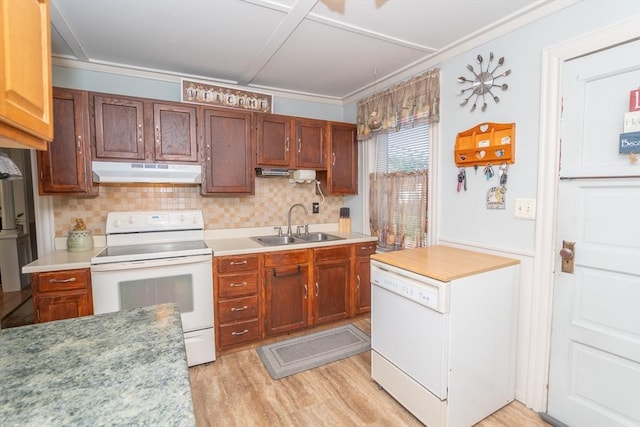 kitchen featuring decorative backsplash, a sink, under cabinet range hood, light wood-type flooring, and white appliances