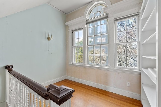 interior space featuring baseboards, crown molding, and wood finished floors