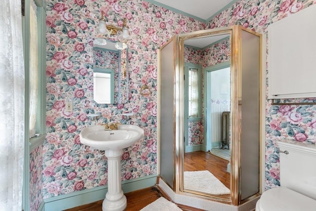 bathroom with toilet, baseboards, wallpapered walls, wood finished floors, and ornamental molding