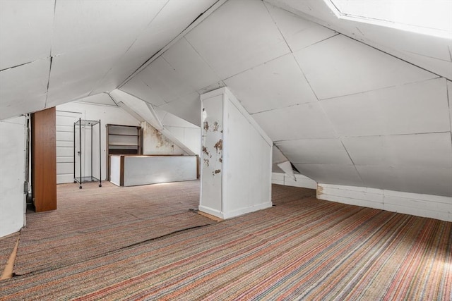 additional living space featuring lofted ceiling and carpet