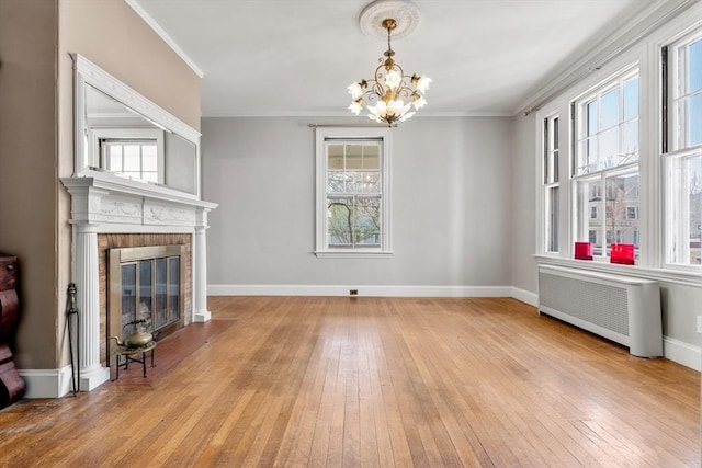 unfurnished living room with radiator, wood-type flooring, and ornamental molding