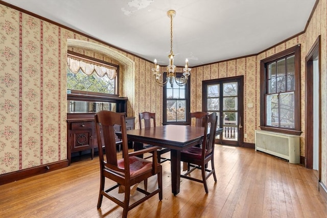 dining space featuring radiator, a chandelier, plenty of natural light, and wallpapered walls